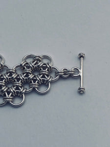 Closeup of toggle on seaXwolf handmade fine jewelry HexaFleur Undulating, 925 solid sterling silver chain mail flower bracelet.